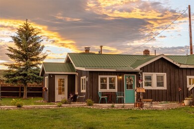 Back house at dusk featuring a lawn
