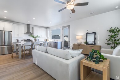 Living area with light wood-type flooring, recessed lighting, and a ceiling fan