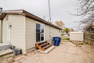 View of side of home with entry steps and a storage unit