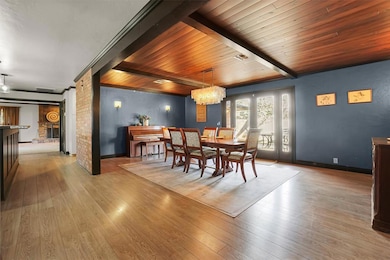 Dining room with light wood-style floors, a chandelier, and a wood ceiling with exposed beams