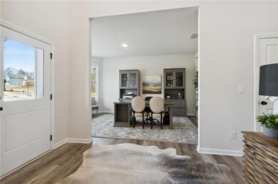 Foyer featuring healthy amount of natural light, wood finished floors, and baseboards