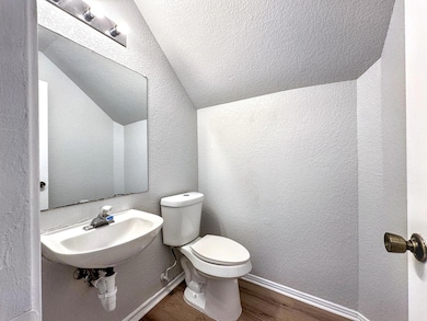 Half bath with a sink, toilet, vaulted ceiling, w