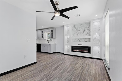 Unfurnished living room featuring a sink, wood fin