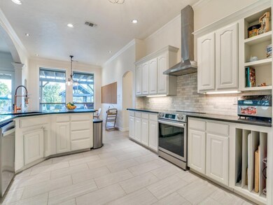 Kitchen with sink, white cabinets, wall chimney ra