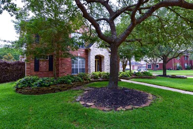 Well-maintained front yard with beautiful trees that provide great shade and privacy and notice the stacked stone landscaping.