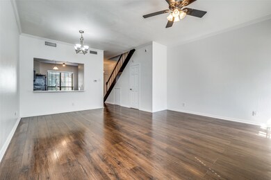 Unfurnished living room with ornamental molding, dark wood-style flooring, a chandelier, and a ceiling fan