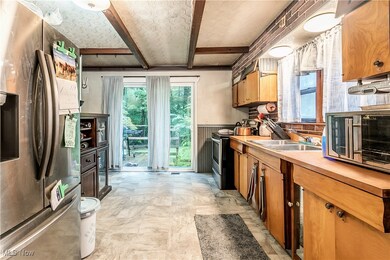 Kitchen featuring light tile patterned flooring, stainless steel appliances, and sink