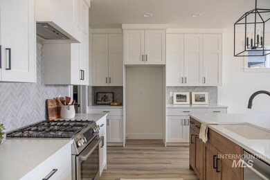 Kitchen featuring appliances with stainless steel finishes, tasteful backsplash, light wood-style flooring, white cabinetry, and light countertops