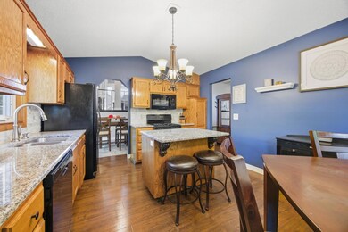 The kitchen features granite counters, a tile backsplash, solid wood cabinetry, and center island!