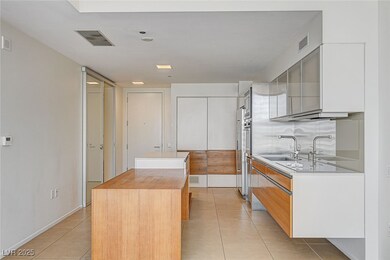 Kitchen featuring a kitchen island, light tile patterned floors, modern cabinets, and white cabinetry