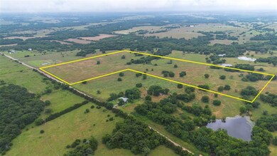 Looking across the acreage with scenic tree coverage and pond views in the distance—great for livestock or recreation.