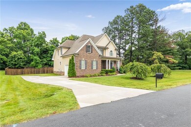 Left corner view of the front of the property showing the large driveway and side 2 car garage.