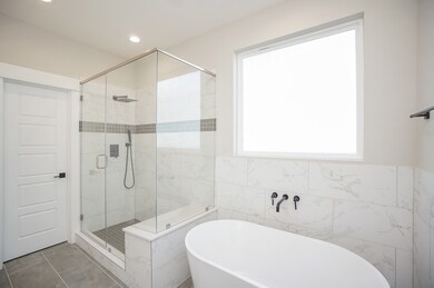 Primary bathroom featuring soaking tub and walk in