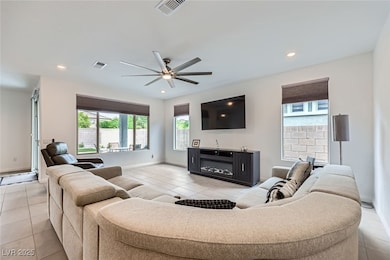 Living room with ceiling fan, light tile patterned