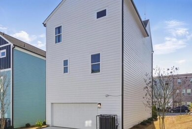 Back of property with cooling unit, a garage, and 
