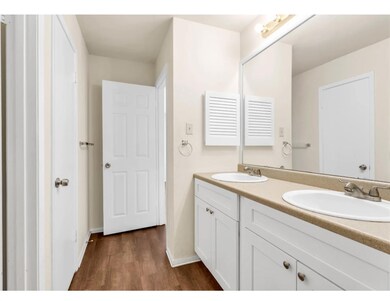 Bathroom with double vanity, wood finished floors
