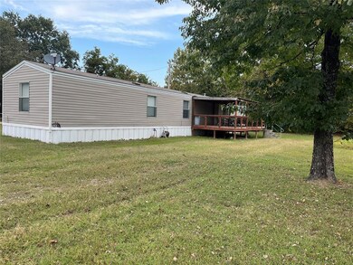 Rear view of property featuring a yard and a woode