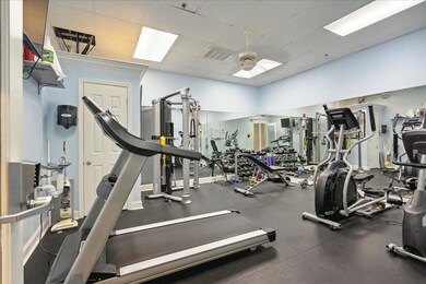 Gym with a ceiling fan and a drop ceiling