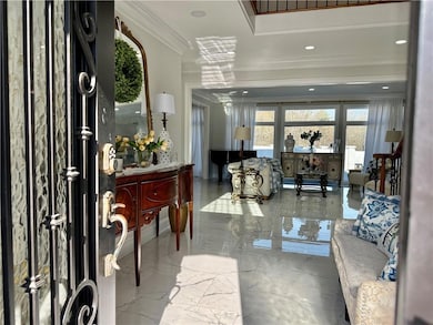 Entrance foyer with ornamental molding, marble tiled floors, and recessed lighting
