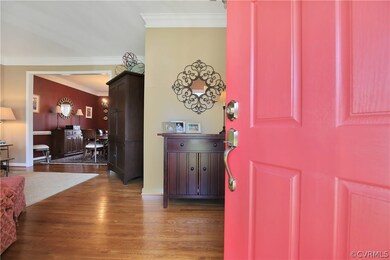 Entryway into the large foyer with hardwood floors and crown molding.