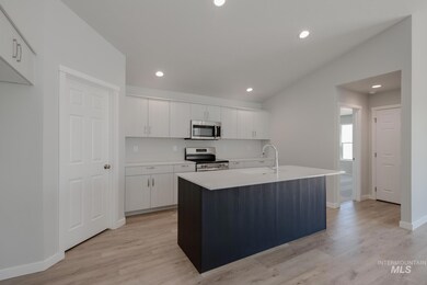 Kitchen featuring an island with sink, recessed lighting, stainless steel appliances, white cabinetry, and light wood-type flooring