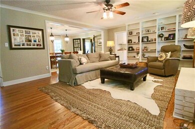 Cozy Great Room with Wood Burning Fireplace, Hardwood Floors and wonderful built-ins! Door leads out to the large Sun Room.