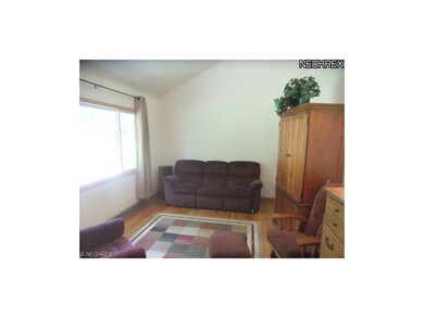 Living room features neutral decor, wood flooring,