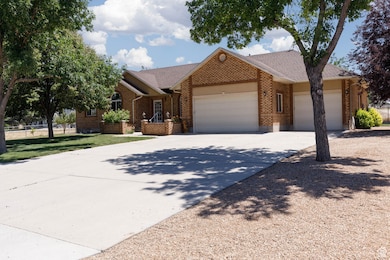 Single story home featuring an attached garage, driveway, brick siding, and a shingled roof