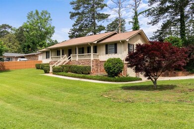 Ranch-style home featuring board and batten siding, covered porch, and stairway