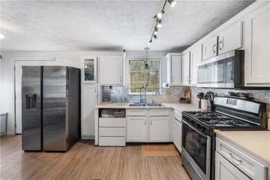 Kitchen with a sink, light wood-type flooring, whi