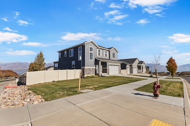 View of front of home featuring a mountain view, a garage, driveway, stucco siding, and stone siding