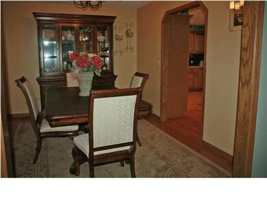 Formal dining room with wood flooring.