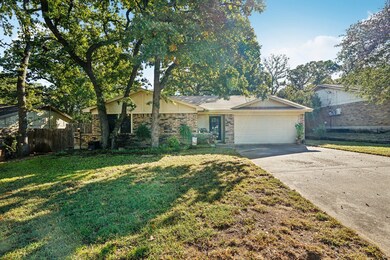 Ranch-style home featuring driveway, a garage, and brick siding