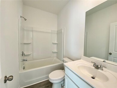 Bathroom with toilet, vanity, tub / shower combination, and wood finished floors