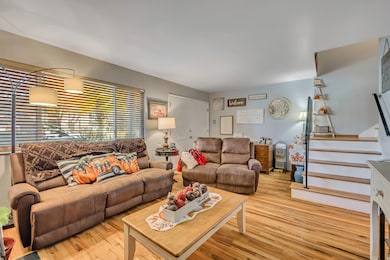 Living room with wood finished floors and stairway