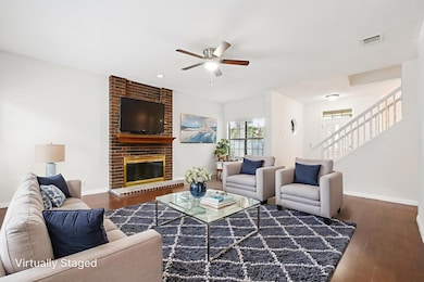 Living area with stairway, ceiling fan, dark wood