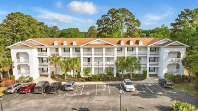 View of building exterior with uncovered parking