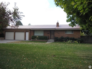 Ranch-style house featuring a front lawn and a garage