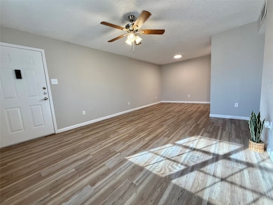 Unfurnished room featuring light wood-style flooring, a textured ceiling, and a ceiling fan