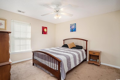 Bedroom featuring light carpet, a textured ceiling, and a ceiling fan