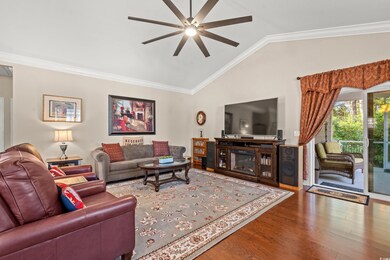 Living room featuring ceiling fan, ornamental mold