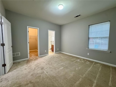 Unfurnished bedroom featuring a spacious closet and carpet floors