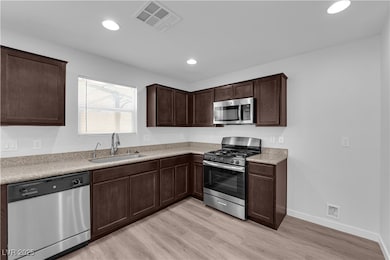 Kitchen with stainless steel appliances, light woo