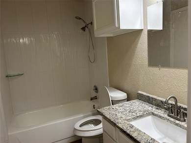 Full bath featuring toilet, vanity, and a textured