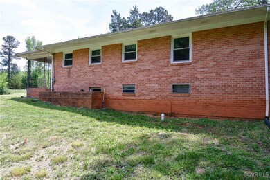 View of side of property featuring a lawn and bric