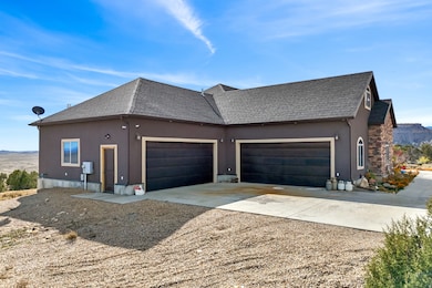 View of side of property featuring concrete driveway, a shingled roof, and stucco siding