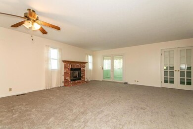 Living room with a fireplace, light carpet, french