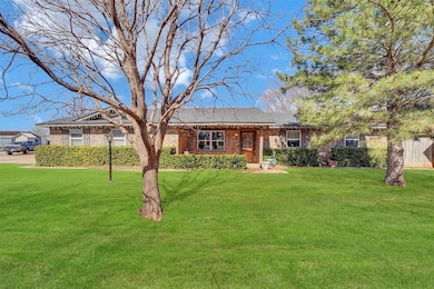 Ranch-style Brick home and a front yard. Evergreen