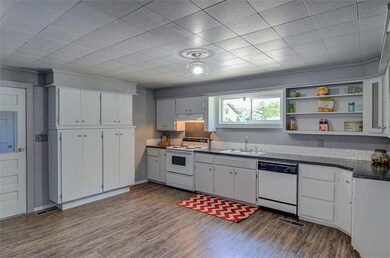 Kitchen with view of extra cabinets and door that 