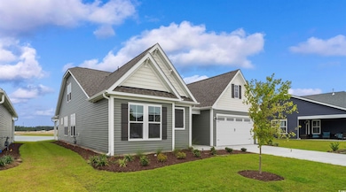 View of front of home with a front yard and a gara